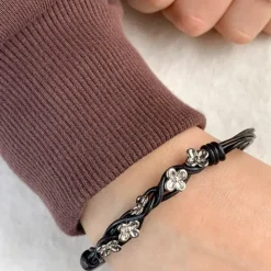 Sort armbånd i læder med blomstervedhæng i rhodineret sølv