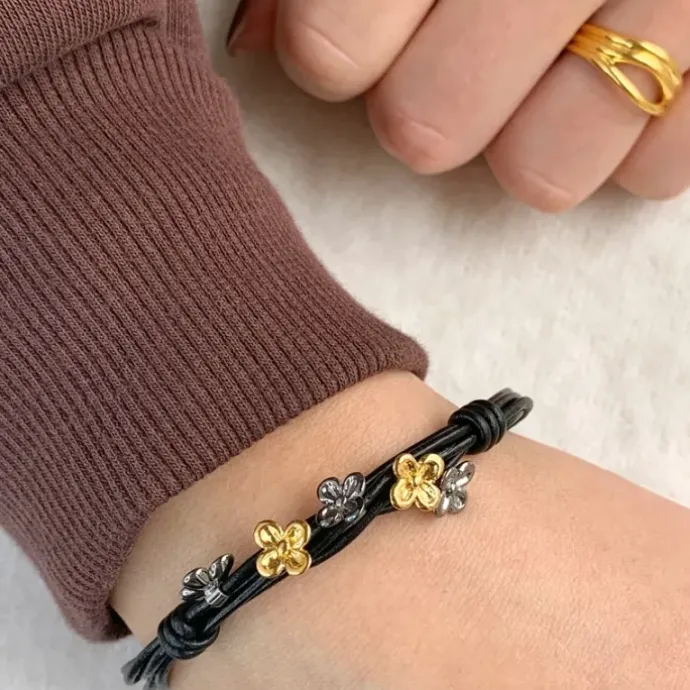 Sort armbånd i læder med blomstervedhæng i Forgyldt og rhodineret sølv